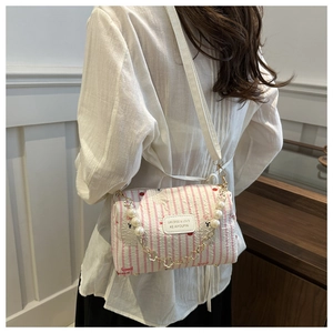 Detail of pink plaid pillow bag featuring pearl chain strap and wrinkled texture fabric