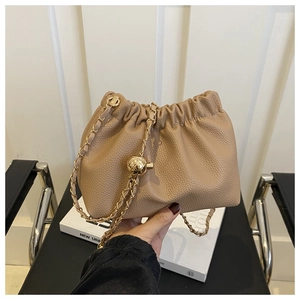 Detail of khaki drawstring cloud bag featuring lychee texture leather and gold chain