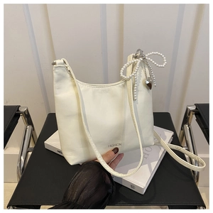 Détail du sac à bandoulière blanc crème avec nœud en perles et lettrage FASHION