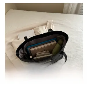 Interior view of black floral tote bag showing high capacity for tablets and essentials