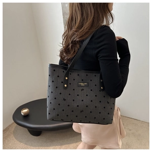 Detailed close-up of grey floral tote bag with bow embroidery and leather shoulder straps