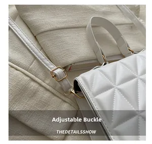 Detail shot of white quilted shoulder bag with gold adjustable buckle and fine stitching