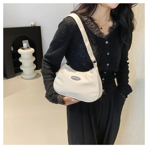 Minimalist white nylon hobo underarm bag for women shown on a model in a modern interior