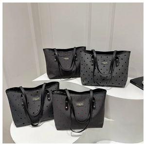 Large black canvas tote bags with various floral patterns and gold metal logos
