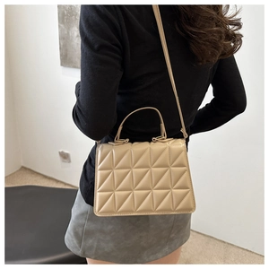 Quilted beige square crossbody bag with geometric triangle texture and top handle strap