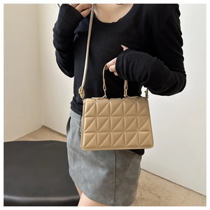 Quilted beige crossbody bag with top handle and elegant chain strap detail