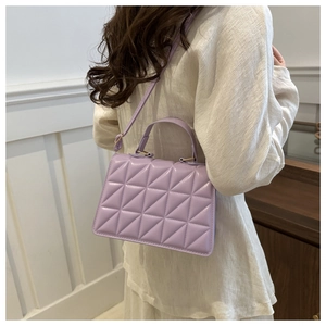 Detail of light purple quilted crossbody bag with classic diamond pattern and top handle