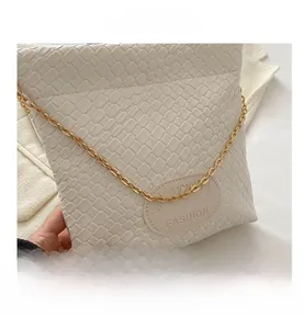 Detailed macro view of white woven texture and gold chain on bucket shoulder bag