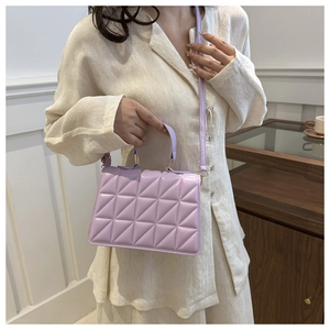 Detail of light purple quilted handbag with adjustable strap worn by a model