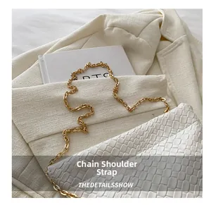 Detail of woven leather texture on white bucket bag with elegant gold chain strap