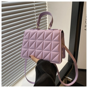 Close-up of lilac quilted handbag with triangular stitching and matching strap