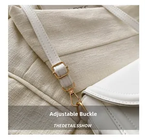 Detail of white lychee leather shoulder strap with adjustable gold metal buckle