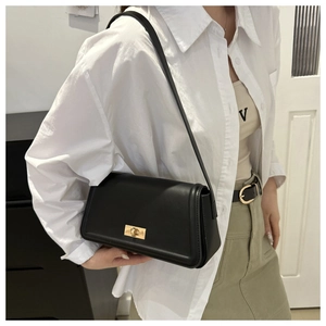 Classic black leather baguette bag with golden buckle shown as a stylish underarm bag