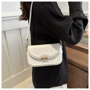 Close-up of white leather square bag featuring golden lock and wavy stitching detail