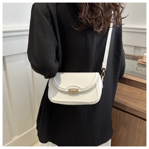 Close-up of a white leather crossbody bag featuring a sleek gold cylindrical metal clasp