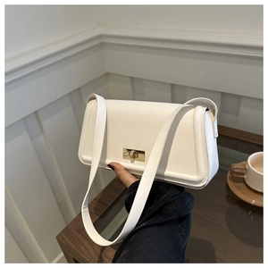 Detail shot of a white faux leather shoulder bag featuring a gold rectangular twist lock