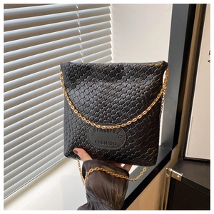 Close-up of black woven texture handbag with golden chain strap and embossed logo detail
