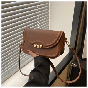 Detail of vintage brown shoulder bag with wavy stitching and gold cylindrical metal lock