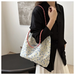 Detail of floral nylon tote bag with drawstring strap and Fashion Instinct brand label