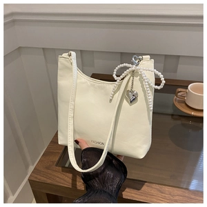 Sac hobo beige chic avec breloque nœud en perles et pendentif cœur argenté élégant