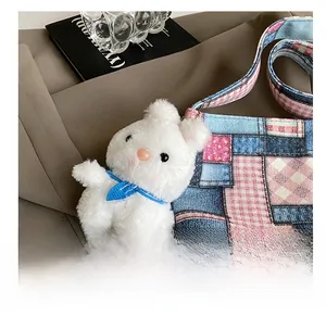 Dettaglio ravvicinato di un ciondolo a coniglio su una borsa a secchiello patchwork vintage