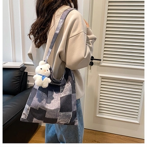 Détail du sac seau en toile patchwork avec un mignon porte-clé lapin en peluche blanc