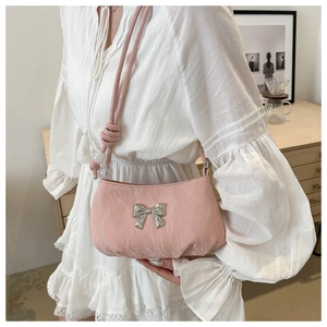 Detail of pink soft fabric shoulder bag with silver bow and beaded rope strap decor