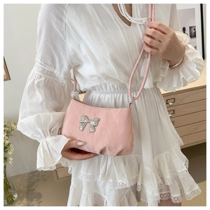 Pink crossbody bag for women with silver bow decoration and soft textured surface