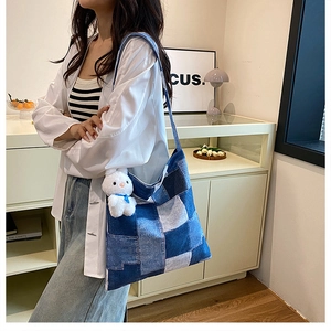 Détail du sac à bandoulière en denim patchwork avec un charmant lapin en peluche blanc
