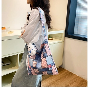 Vue détaillée d'un sac seau en toile avec motif patchwork et pendentif lapin blanc