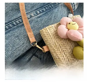 Close-up of durable metal hook and floral detail on summer woven straw crossbody bag
