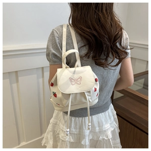 Detailed back view of a white mini drawstring backpack with strawberry and butterfly prints