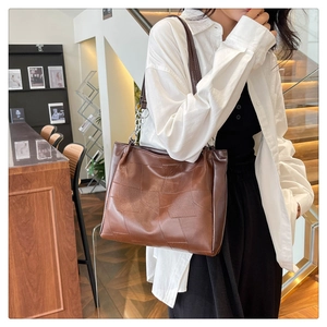 Detail of dark brown vintage tote bag with geometric stitching and silver chain strap