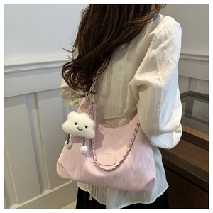 Detail of pink shoulder bag featuring silver chain and cute white cloud plush pendant