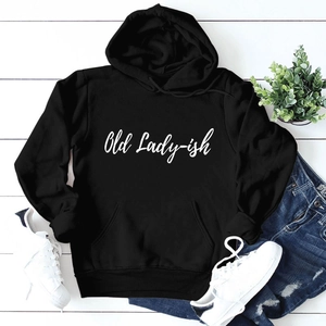 Close-up of black 'Old Lady-ish' hoodie laid flat with jeans and casual white sneakers