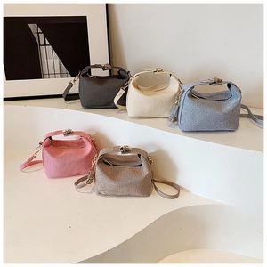 Minimalist fabric pillow bags in multiple colors with unique metal handles and straps