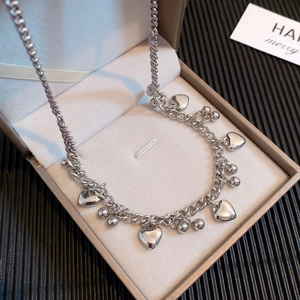 Zilveren dikke schakelketting met gepolijste hartjes en kralen in een juwelendoosje