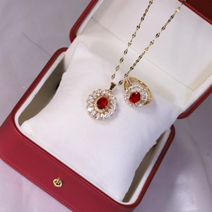 Détail macro d'un ensemble de bijoux dorés avec gemme rouge dans un écrin de luxe