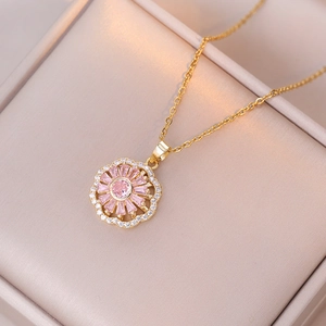 Gouden rvs ketting met draaiende bloem hanger, roze kristallen en glanzende strassteentjes