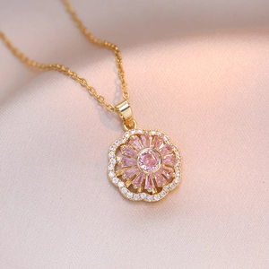 Macro-opname van draaibare bloemhanger met roze zirkoon en gouden ketting op zijde