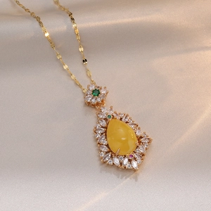 Golden necklace with teardrop yellow gemstone and zircon pavé on silk fabric