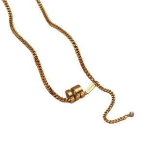 Collier à maille gourmette dorée avec pendentif cylindrique texturé et détail zircon