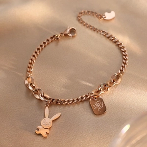 Rose gold titanium steel bracelet with cute rabbit and heart charm on satin background
