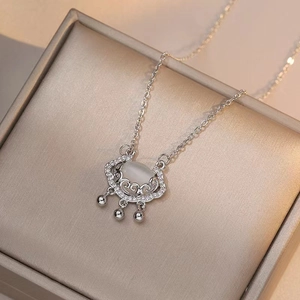 Silver Ruyi lock pendant necklace featuring a milky cat eye stone and pave diamonds