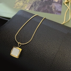 Élégant collier en titane doré avec pendentif carré en nacre sur un support en cuir noir