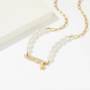 Elegante collana girocollo dorata con ciondolo Lucky e stella di perle su display