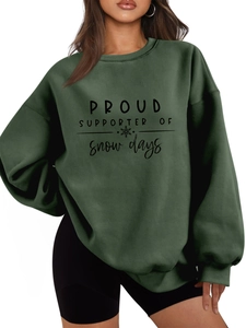 Close-up of forest green plush sweatshirt featuring black snow days text and snowflake icon