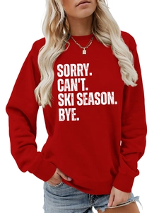 Close-up of Sorry Can't Ski Season Bye text print on red cotton sweatshirt fabric
