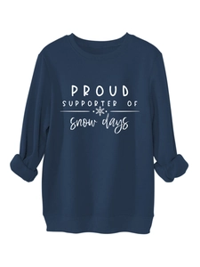 Detailed close-up of navy blue winter sweatshirt with white snowflake print and ribbed cuffs