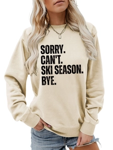 Detail of the Sorry Can't Ski Season Bye text on a beige crewneck sweatshirt